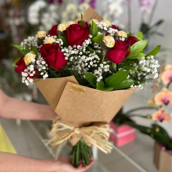 Mulher segurando buquê de 12 rosas vermelhas com bombons Ferrero Rocher
