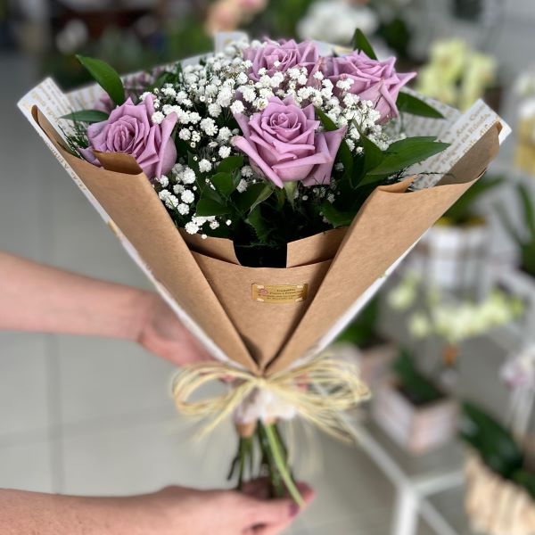 Detalhe das rosas lilás e da embalagem personalizada com escritos da Floricultura Camélia, buquê de rosas em São Paulo.