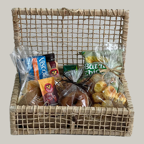 Cesta Camélia rústica de café da manhã em São Paulo Zona Norte, recheada com croissants, pães de queijo e itens de padaria artesanal, decorada pela Floricultura Camélia.