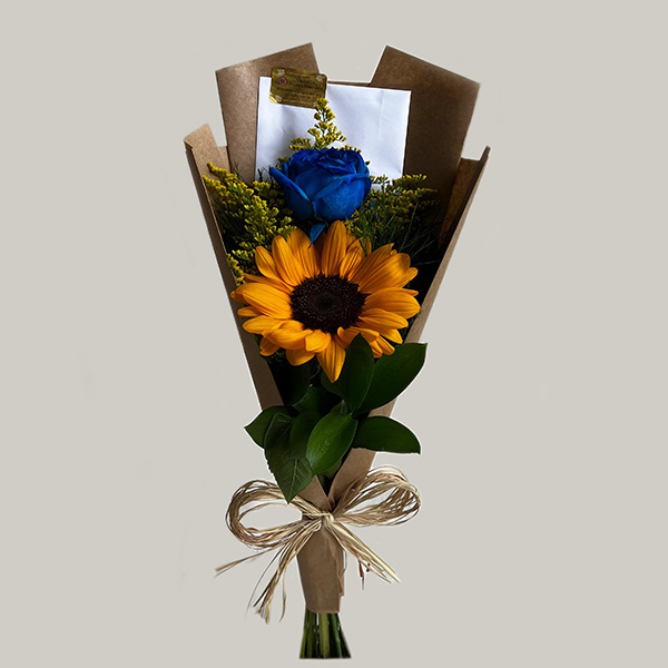 Buquê de girassol em São Paulo com rosa azul e embalagem de papel kraft da Floricultura Camélia.